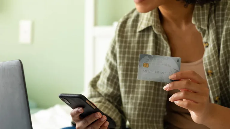 Woman deciding between Credit Card or Debit Card.