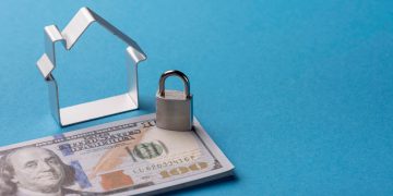 Illustrative image of Secured Loans with miniature house, padlock and money.