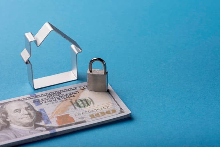 Illustrative image of Secured Loans with miniature house, padlock and money.